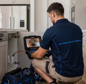 Plumber clearing a blocked toilet in a Luddenham bathroom